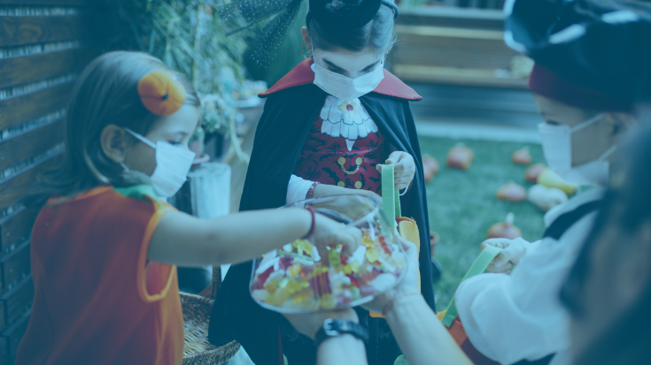 Children wearing masks and costumes while trick or treating.